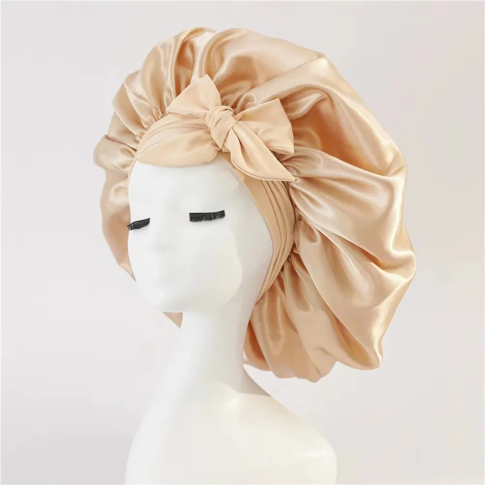 Beige satin head wrap with a bow on a mannequin head against a white background