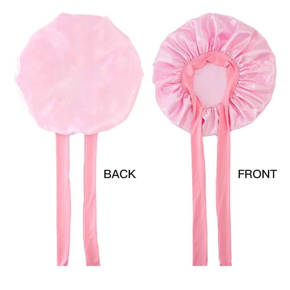 Pink satin bonnet with ribbons on a white background