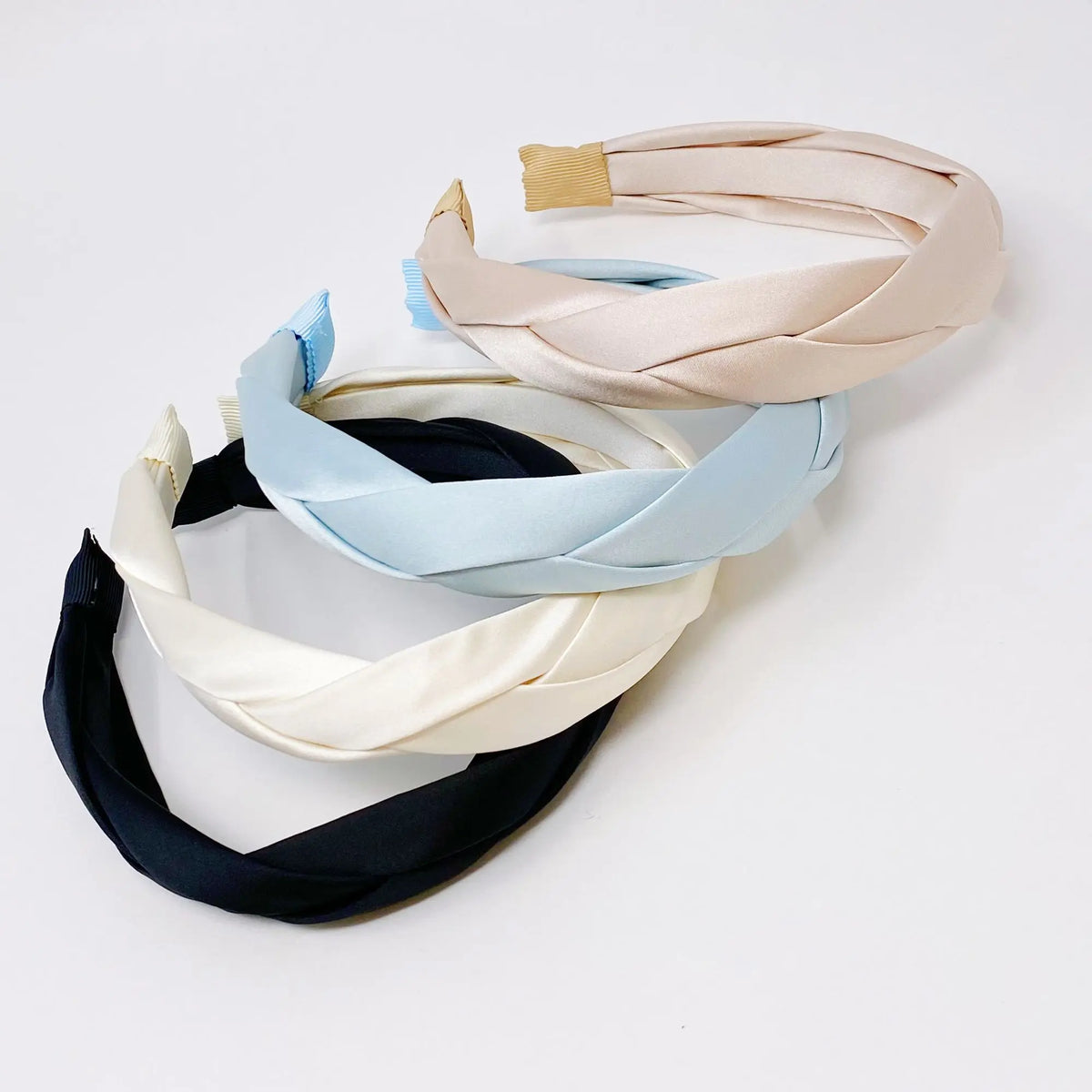 Set of four headbands in black, white, blue, and beige on a light gray background